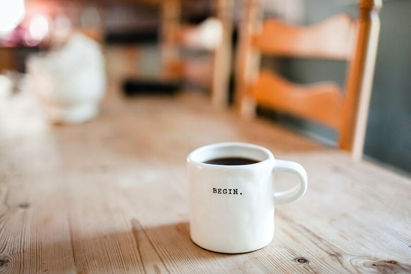 coffee in a mug that says "begin."